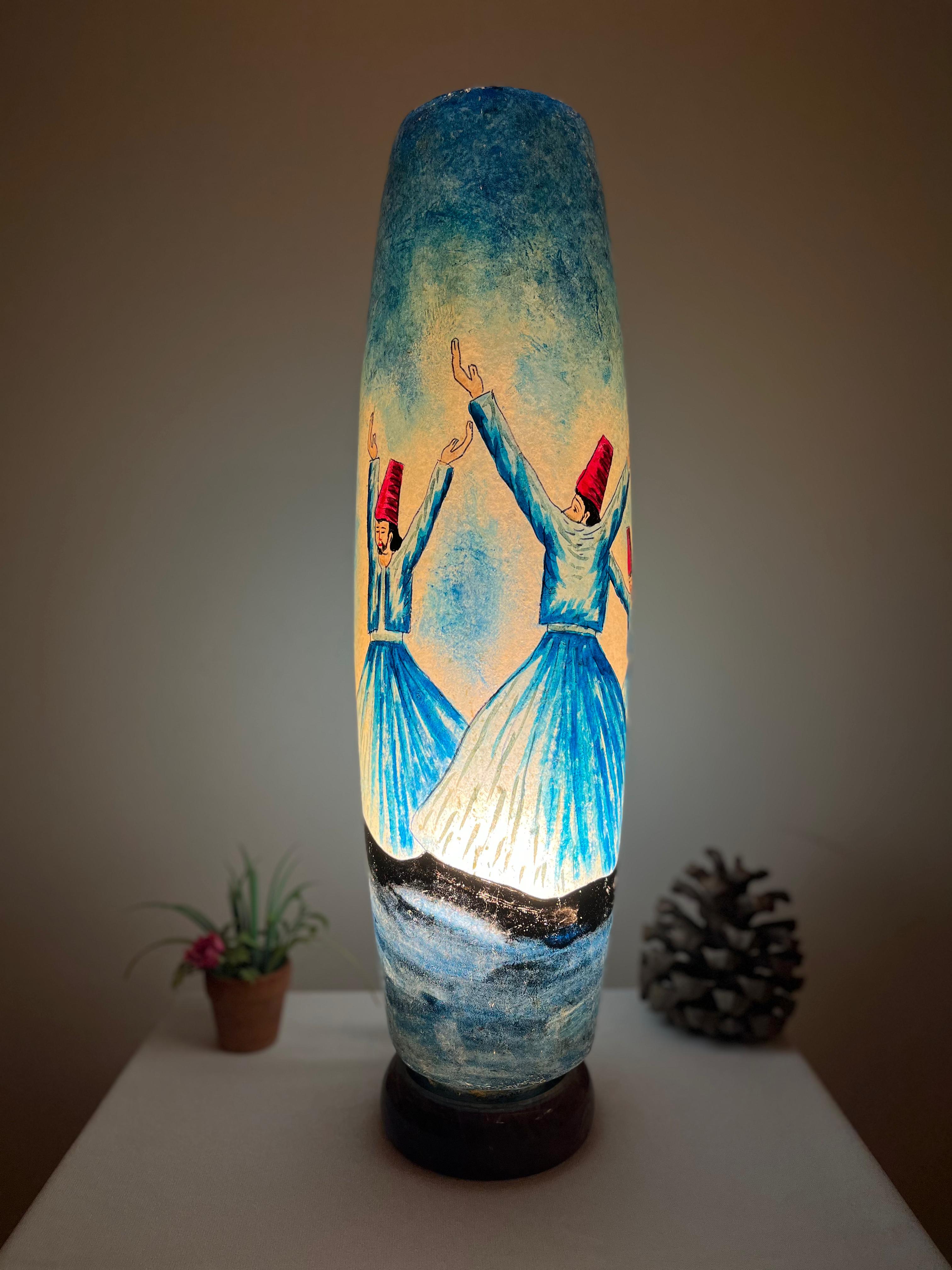 Decorative lamp with artistic design of dervish on a white surface.