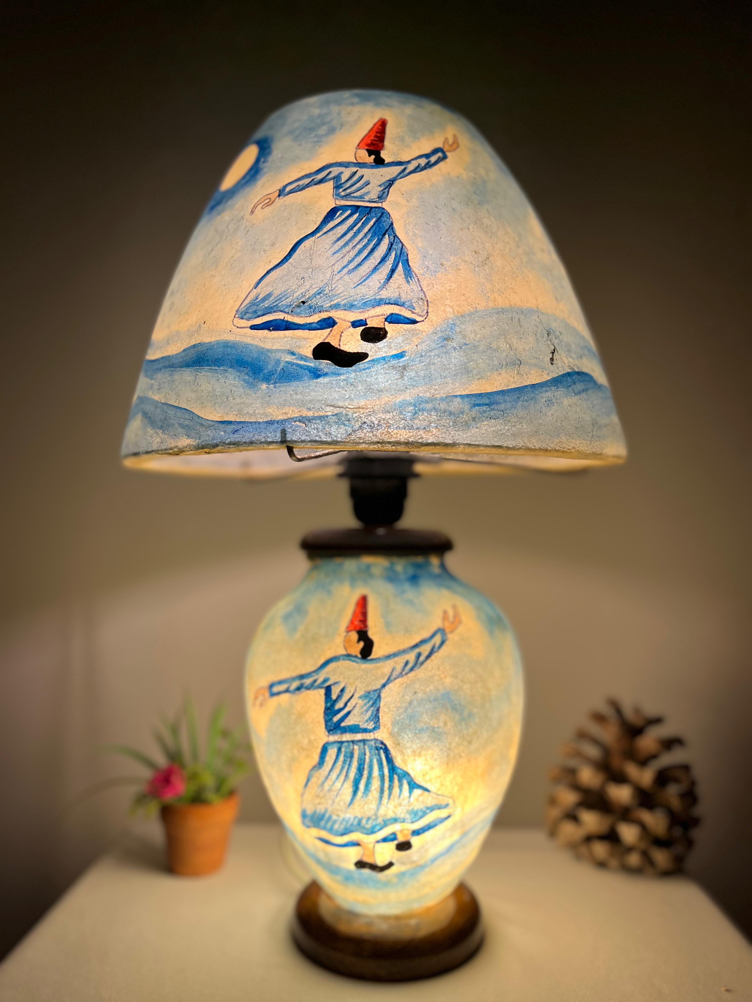 Decorative lamp with a painted design on a dark background